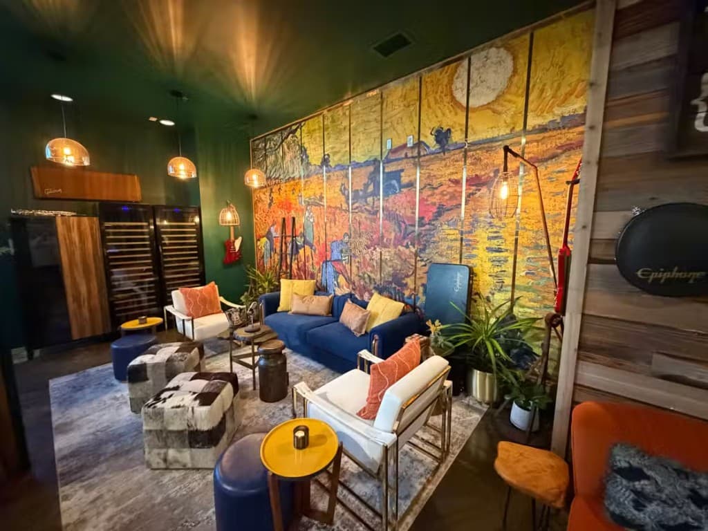 Rotation lounge interior with velvet seating, mural, warm lighting, and wine display.